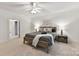 Spacious main bedroom featuring hardwood floors, a ceiling fan, and modern decor at 2411 Calais Pl, Charlotte, NC 28211