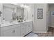 Bright bathroom features double sink vanity with white cabinets and a decorative mirror at 250 Kerri Dawn Ln, Locust, NC 28097