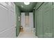 This bathroom features sage-colored walls, white hexagon tile flooring, and a shower-tub combination with white shower curtain at 2500 Cranbrook Ln # 2, Charlotte, NC 28207