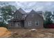 Newly constructed two-story home featuring a brick facade and an inviting front porch at 2720 Old Course Rd, Monroe, NC 28112