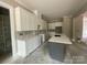 Unfinished kitchen showcasing custom white cabinetry, a gray island, and countertops with white marble accents at 2720 Old Course Rd, Monroe, NC 28112
