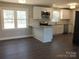 Open-concept kitchen featuring granite countertops, stainless steel appliances, white cabinets, and wood-look flooring at 2739 Great Falls Hwy, Lancaster, SC 29720