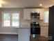 Modern kitchen with stainless steel appliances, granite countertops, white cabinets, and a large window at 2739 Great Falls Hwy, Lancaster, SC 29720