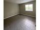 A vacant bedroom with tile flooring, neutral walls, and a window for natural light at 300 Orchard Trace Ln # 3, Charlotte, NC 28213