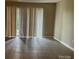 A vacant living room with tile floors, vertical blinds, and a sliding glass door at 300 Orchard Trace Ln # 3, Charlotte, NC 28213