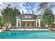 Stunning backyard featuring a pool and the home's rear facade, enhanced with an awning and elegant patio furniture at 318 S Canterbury Rd, Charlotte, NC 28211