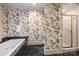 Bathroom showcasing vibrant floral wallpaper, a soaking tub, and a glass-enclosed shower at 318 S Canterbury Rd, Charlotte, NC 28211