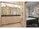 Elegant bathroom featuring floral wallpaper, green marble, soaking tub, and double sink vanity at 318 S Canterbury Rd, Charlotte, NC 28211