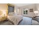 Bedroom featuring a queen bed, with a sitting chair, large windows and neutral carpet at 318 S Canterbury Rd, Charlotte, NC 28211