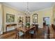 Chandelier-lit dining room featuring herringbone floors and open view to living room at 318 S Canterbury Rd, Charlotte, NC 28211