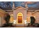 Up close detailed front exterior of light pink home featuring arched doorway, manicured plants, and stone steps at 318 S Canterbury Rd, Charlotte, NC 28211