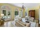 Bright living room with yellow walls, tiled floors, arched windows/doorways, and a view of the outdoor pool area at 318 S Canterbury Rd, Charlotte, NC 28211