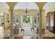 Bright living room with yellow walls, pillars, arched windows/doorways, and a view of the outdoor pool area at 318 S Canterbury Rd, Charlotte, NC 28211