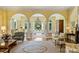 Bright living room with yellow walls, hardwood floors, arched windows/doorways, and a view of the pool area at 318 S Canterbury Rd, Charlotte, NC 28211