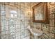 Charming powder room featuring a pedestal sink, patterned wallpaper and ornate mirror at 318 S Canterbury Rd, Charlotte, NC 28211