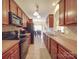 Galley kitchen features stainless appliances, tile backsplash, and view into the dining area at 3253 Ian Patrick Ave, Kannapolis, NC 28083