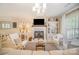 Open-concept living room featuring fireplace, stylish white furniture, and view into the dining area at 3601 Rosedown Dr, Matthews, NC 28105