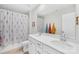 Bright bathroom featuring a double sink vanity, a large mirror, and a shower with a floral curtain at 367 Kennerly Center Dr, Mooresville, NC 28115