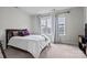 This bedroom features light, neutral paint, plush carpet, and lots of natural light from the three windows at 3750 Ellington St, Charlotte, NC 28211