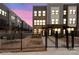 Modern townhome exteriors at dusk with fenced yards, paved walkways, and tidy landscaping at 3750 Ellington St, Charlotte, NC 28211