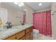 Bathroom featuring double sinks with granite countertops, wood cabinets, and decorative shower curtain at 4119 Flint Dr, Lancaster, SC 29720