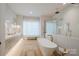 Bright bathroom featuring a soaking tub, glass shower, double sink vanity, and neutral color palette at 412 Bertonley Ave, Charlotte, NC 28211