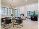 Bright dining room with a glass table, modern chandelier, and an open view into the well-lit living room at 412 Bertonley Ave, Charlotte, NC 28211