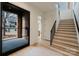 Welcoming foyer with staircase, black-framed glass door, and light hardwood floors at 412 Bertonley Ave, Charlotte, NC 28211