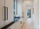 Bright hallway with white cabinets, black countertop, brass fixtures, and access to the exterior at 412 Bertonley Ave, Charlotte, NC 28211