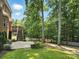 Expansive backyard featuring a brick patio, deck with stairs, green lawn, mature trees, and a white picket fence at 4708 Pearmain Dr, Waxhaw, NC 28173