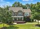 Charming brick home with a covered front porch and beautifully landscaped front yard on a sunny day at 4708 Pearmain Dr, Waxhaw, NC 28173