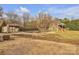 The spacious backyard features a utility shed and rustic barn amid a field of dormant grass at 49 Orchard Trace Ct, Taylorsville, NC 28681