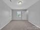 This bedroom provides neutral colored walls and carpet and a window with exterior light at 49 Orchard Trace Ct, Taylorsville, NC 28681