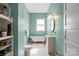 Charming bathroom featuring a clawfoot tub, a pedestal sink, and light green walls at 524 W Horah St, Salisbury, NC 28144