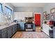 Functional kitchen with blue cabinets, stainless steel appliances, and a vibrant red door at 524 W Horah St, Salisbury, NC 28144