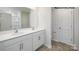 Bright bathroom featuring double sink vanity, white cabinets, gray flooring, and large mirror at 529 Trading Post Ln, York, SC 29745