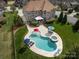 Aerial view of backyard featuring a freeform pool, hot tub, lounge chairs, and landscaped yard at 5501 Two Iron Dr, Matthews, NC 28104