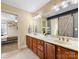 Bathroom featuring double sinks, vanity, wooden cabinetry, and a barn door leading to the bedroom at 5501 Two Iron Dr, Matthews, NC 28104