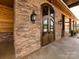 Custom wood doors with iron detailing and stone facade on a community building entrance at 5501 Two Iron Dr, Matthews, NC 28104