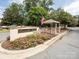 Community entrance with lush landscaping, signage, and an American flag waving at 5501 Two Iron Dr, Matthews, NC 28104