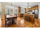 Kitchen and breakfast nook area featuring hardwood floors, central island, and stainless steel refrigerator at 5501 Two Iron Dr, Matthews, NC 28104