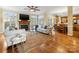 Spacious living room featuring fireplace, TV, hardwood floors, and open layout connected to the kitchen at 5501 Two Iron Dr, Matthews, NC 28104