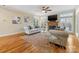 Bright living room featuring a fireplace, TV, hardwood floors and two couches in a well-lit space at 5501 Two Iron Dr, Matthews, NC 28104