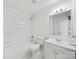 Bright, clean bathroom with white tile, shower-tub, modern vanity and mirror at 5600 Burleson Dr, Charlotte, NC 28215