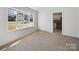 Cozy bedroom featuring neutral carpet, a large window, and ample natural light at 5600 Burleson Dr, Charlotte, NC 28215