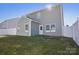 View of the backyard of a two-story gray house with a white fence at 616 Smokehouse Ln, Albemarle, NC 28001