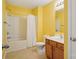 Bright yellow bathroom features a tub/shower combo and wood vanity at 616 Smokehouse Ln, Albemarle, NC 28001