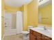 Bright yellow bathroom features a tub/shower combo and wood vanity at 616 Smokehouse Ln, Albemarle, NC 28001