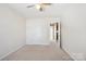 Bright bedroom featuring neutral carpet, a ceiling fan, and a door with connecting bathroom at 616 Smokehouse Ln, Albemarle, NC 28001