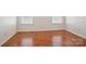 Neutral bedroom with hardwood floors and natural light from two windows at 616 Smokehouse Ln, Albemarle, NC 28001